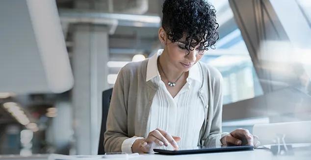 A woman navigating and reviewing behavioral finance information on a tablet