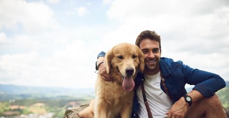 Cropped portrait of a handsome young man and his dog taking a break during a hike in the mountains.