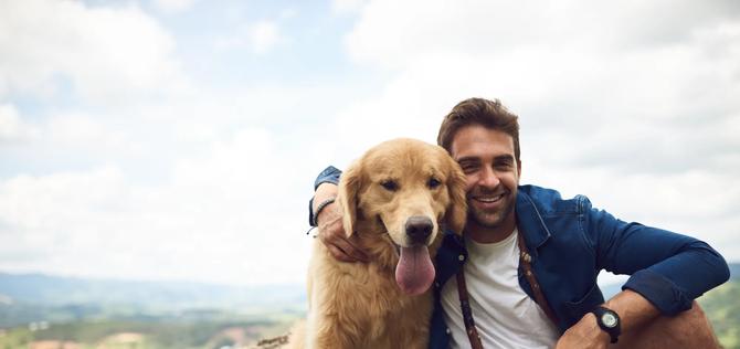 Cropped portrait of a handsome young man and his dog taking a break during a hike in the mountains.