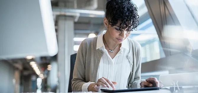 Businesswoman using digital tablet at office desk