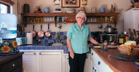 Smiling senior woman preparing a meal in the kitchen 