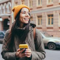 Attractive young woman tourist talking on mobile phone in the city