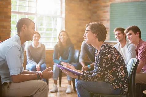 Group watching man and woman talking in group