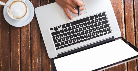 Woman ( hand only) typing on a computer sitting at table 