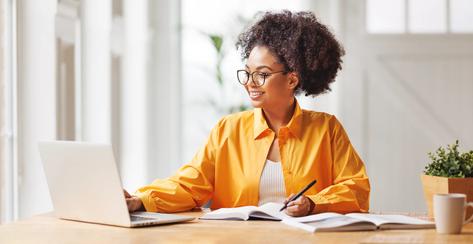 beautiful smiling african american woman  works remotely on laptop from home