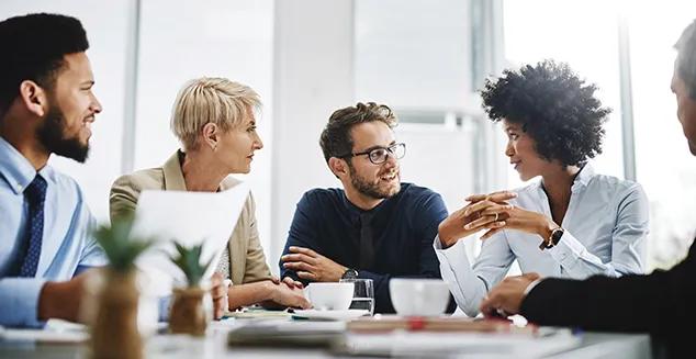 Five diverse team members collaborating during a meeting. 