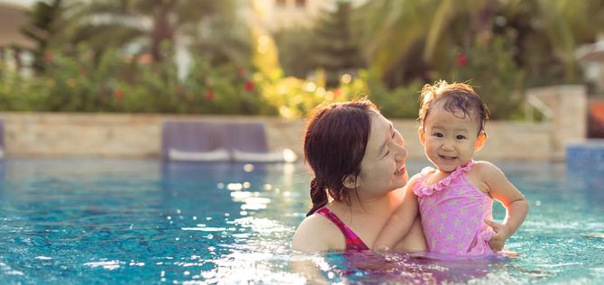 Baby and mom playing in swimming pool