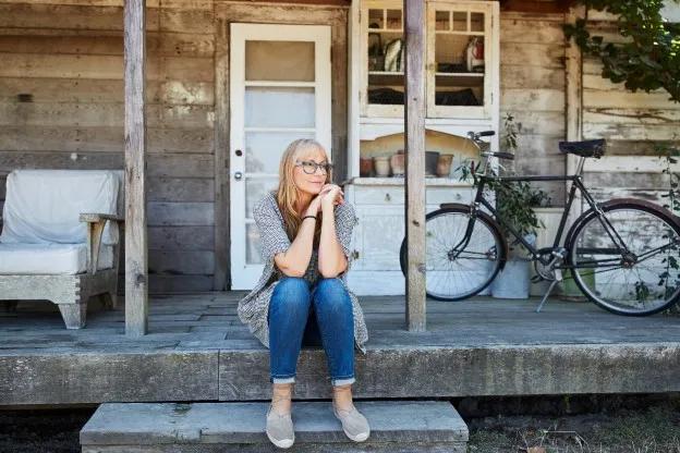 Woman sitting on the front steps of a house.