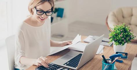 Happy cute  pretty accountant working with computer and calculator