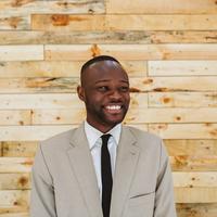 Portrait of a happy young african businessman over a wooden wall.