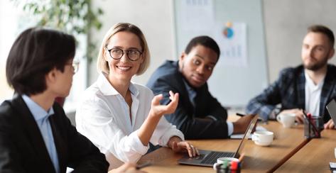 Diverse Business People Having Meeting, Discussing Work Projects And Startup Ideas Sitting At Table In Modern Office. Corporate Meeting, Teamwork And Brainstorming. Selective Focus