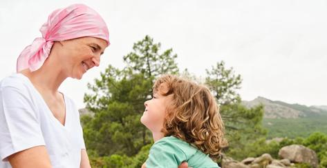 Woman wearing a head scarf looking at a young child.