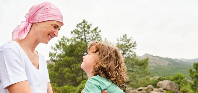 Woman wearing a head scarf looking at a young child.