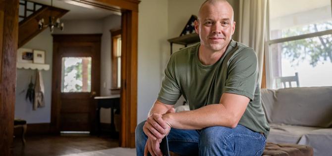 Marine veteran at home with family poses for portrait.