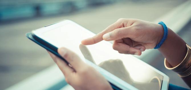 Close up of young womans hands using touchscreen on digital tablet