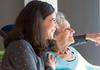 Joyful woman taking care of elderly mother