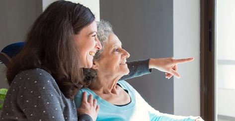 Joyful woman taking care of elderly mother