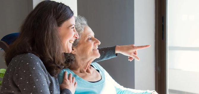 Joyful woman taking care of elderly mother