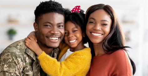 A veteran smiling at the camera with his family.