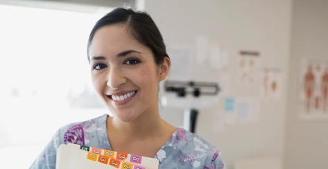 Portrait of smiling nurse holding medical charts