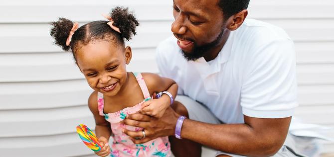 Father playing with giggling daughter 