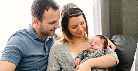 Mom and Dad holding an infant baby.