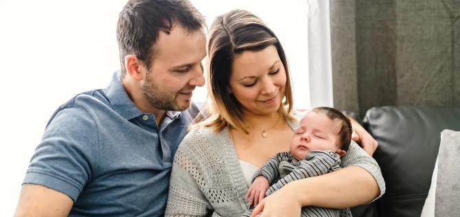 Mom and Dad holding an infant baby.