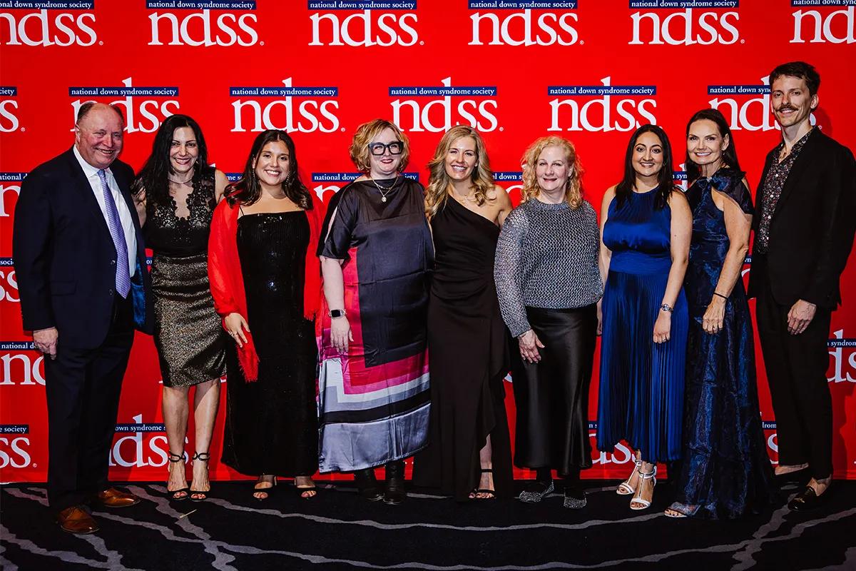 Group of well dressed Voya employees supporting the National Down Syndrome society at a fundraising event.