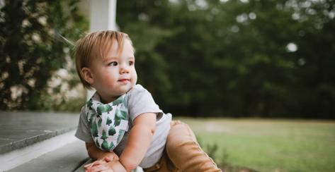 This is an image of a one-year-old boy climbing the stairs of a house