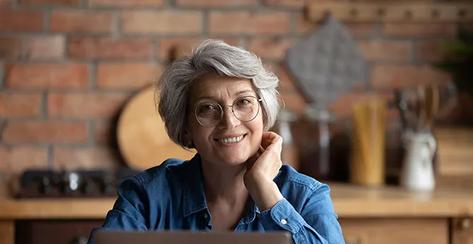 Smiling senior hispanic female using laptop