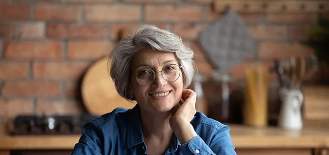 Smiling senior hispanic female using laptop