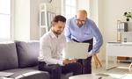 Two male colleagues working together with laptop in office. Businessmen discussing their project during meeting. Business partners in formal wear sharing business ideas, discussing contract, agreement