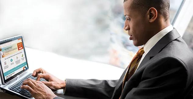 A male professional using a notebook computer to review financial information on Voya Digital Adviser