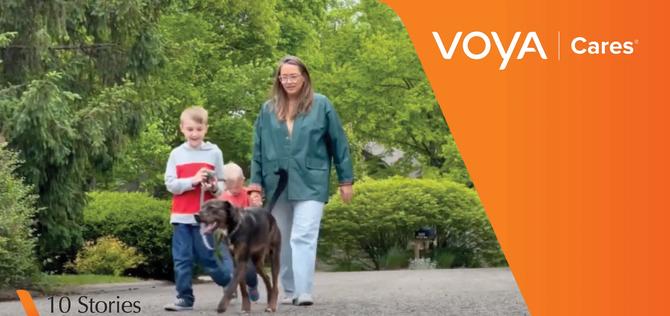 Young family of a mom with two young boys walking a dog