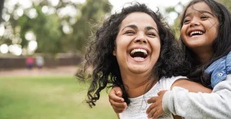 Happy mother having fun with her daughter outdoors