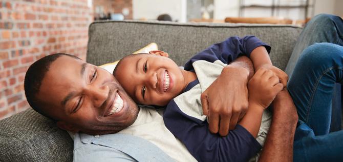 Father And Son Cuddling On Sofa Together; Shutterstock ID 627662744; Purchase Order: Creative Services; Job: Creative Services; Client/Licensee: Voya Financial; Other: AG