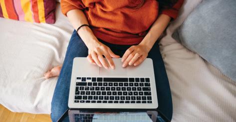 Overhead close up of a young woman working on laptop