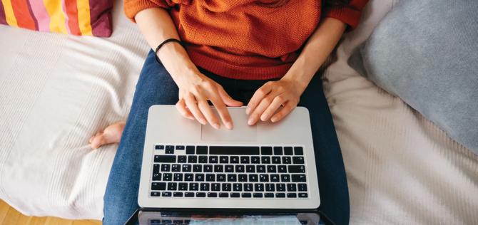 Overhead close up of a young woman working on laptop