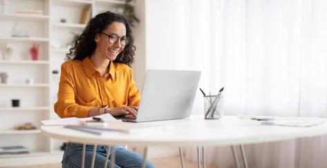 Happy Middle Eastern Businesswoman Using Laptop Sitting At Workplace