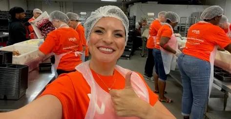 Woman volunteering in hairnet and giving the thumbs-up
