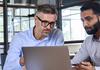 two men looking at laptop
