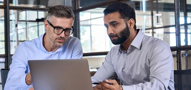 two men looking at laptop