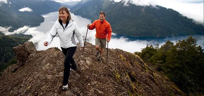 A couple hiking along a rocky trail.