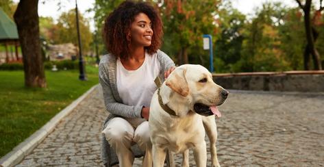 Woman walking outside with a dog.