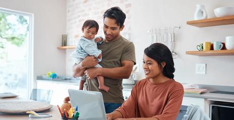 Internet, family and parents doing research on down syndrome with baby on a laptop in their house. Mother and father with smile for child and working on taxes or finance budget on the computer.