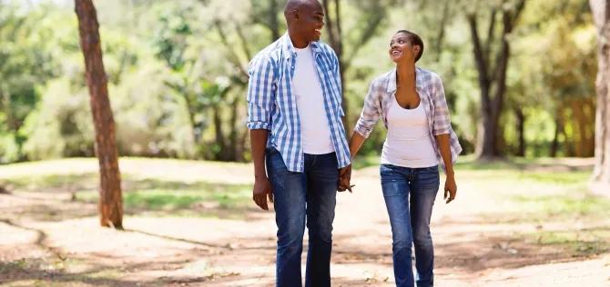 African American couple holding hands while walking in nature 
