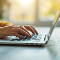 Close up of hand typing on laptop keyboard with blurred background and copy space for text